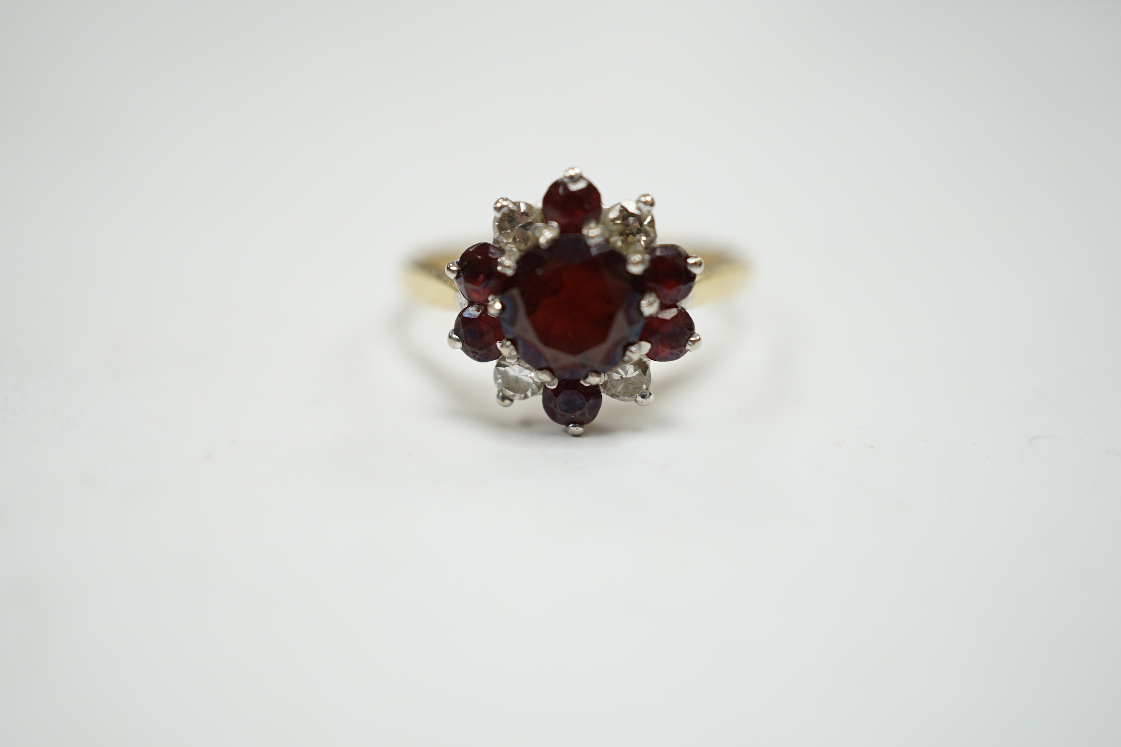 An 18ct red paste? and diamond cluster set flower head ring, size M, gross weight 3.2 grams.